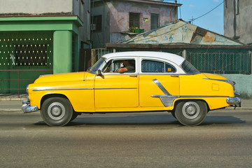 Yellow Pontiac driving through the streets of Havana, Cuba