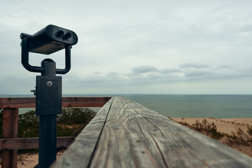 Binoculars for the observation deck on the beach at the wooden railing