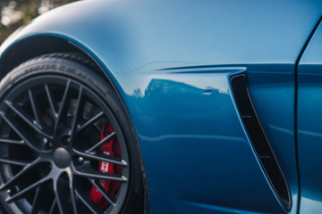 Obraz na płótnie Canvas Blue brand sport model car front black wheel