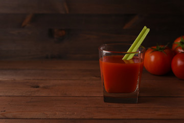 Tomato juice with celery and tomatoes on dark wooden background. Copy space. 