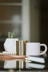 Modern Coffee Table with Coffe Mug, Gold Candle, and Cactus