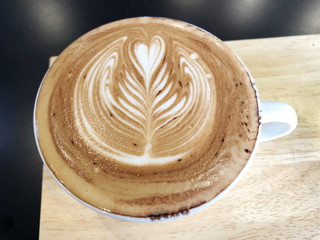 Cappuccino or latte with frothy foam, white coffee cup top view