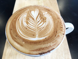 Cappuccino or latte with frothy foam, white coffee cup top view