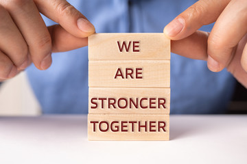 Man ' s hand Holding Wooden Building Blocks. Motivational Concept