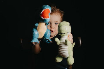 portrait of a happy child boy playing with dinosaur toys