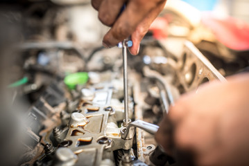 The mechanic is about to adjust the valve clearance. Adjust or tune the car valve.