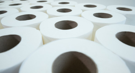 Many white toilet paper rolls, close up with shallow depth of field.