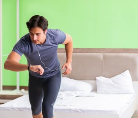 Fototapeta premium Young handsome man doing morning exercises in the hotel room