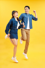 Obraz premium Full length body size view of nice attractive lovely cheerful cheery couple jumping up in air isolated over yellow background