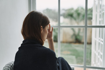 young woman looking out window