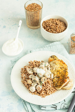 Grilled chicken breast, mushroom and tasty buckwheat porridge. Dietary balanced food. Light grey concrete background. Toned image.