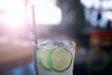 lemonade in glass cafe / fresh lemonade with ice and lime in a glass on a restaurant background