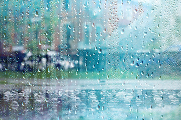 summer rain wet glass / abstract background landscape on a rainy day outside the window blurred background