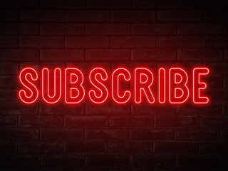Subscribe - red neon light word on brick wall background 