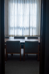 Backlit conference table and chairs through a doorway