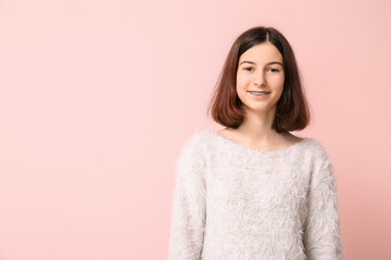 Fototapeta premium Teenage girl with dental braces on color background