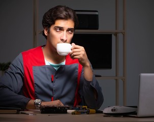 Young handsome repairman repairing computer