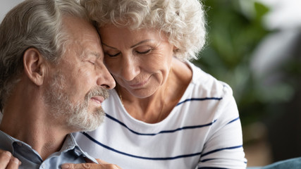 Happy mature couple in love enjoying tender moment close up, older wife and husband with closed...