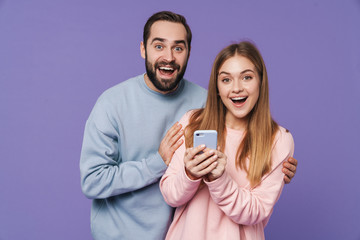 Excited surprised loving couple using mobile phone.