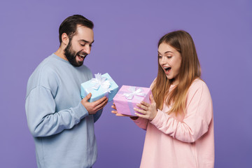 Loving couple isolated over purple wall