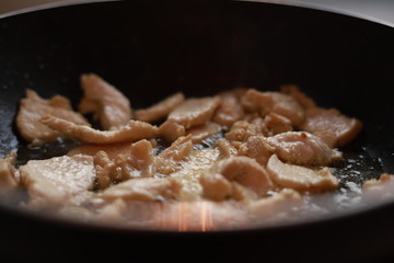 Oil fried pork in a frying pan.