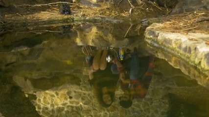 A couple's reflection on water on a romantic date in nature