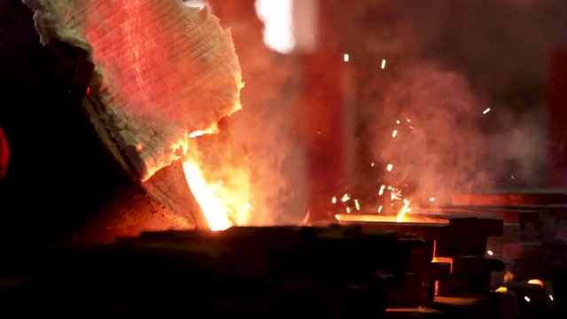 Molten metal being poured from hopper to cast at a foundry