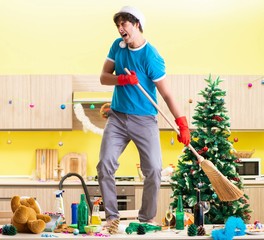 Young man cleaning kitchen after Christmas party