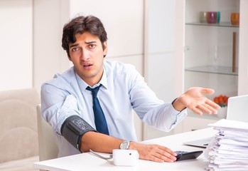 Man under stress measuring his blood pressure