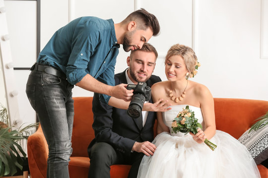 Photographer working with young wedding couple in studio