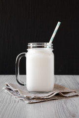 Coconut milk in a glass jar, side view. Close-up.