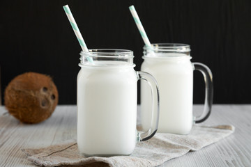 Glass jars filled with coconut milk, side view. Close-up.