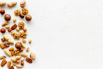 Nuts background - with almond, macadamia, walnut - on white table top-down frame copy space
