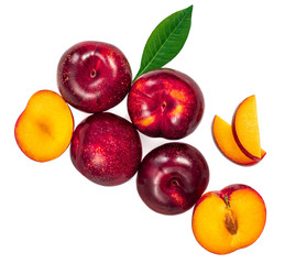 Fresh ripe whole and cut Plums with leaves isolated on white background.
