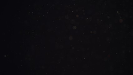 Fototapeta premium 4k Natural Dust Organic Floating particles on black background. Dust in air atmosphere for your projects! Just drop it over your footage and use blending (screen) mode