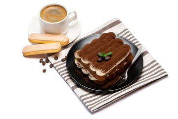 Classic tiramisu dessert on ceramic plate, savoiardi cookies and cup of coffee isolated on white background with clipping path
