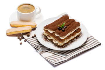 Classic tiramisu dessert on ceramic plate, savoiardi cookies and cup of coffee isolated on white background with clipping path