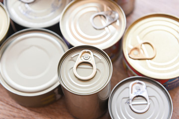 Various canned food in metal cans on wooden background , top view canned goods non perishable food storage goods in kitchen home or for donations