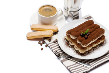 Classic tiramisu dessert on ceramic plate, savoiardi cookies and cup of coffee isolated on white background with clipping path