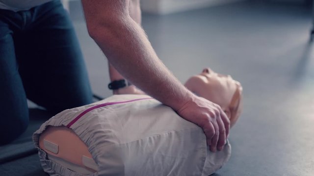 Emergency training instructor, perfoming cpr on emergency test doll.