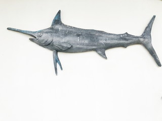 Stucco Gray fish statue decorated on the wall.