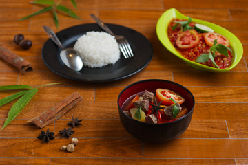 indonesian beef stew on a black bowl over wooden background. traditional meat soup.