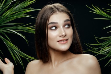 Fototapeta premium Beautiful woman naked shoulders green leaves spa treatments