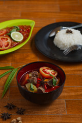 indonesian beef stew on a black bowl over wooden background. traditional meat soup.