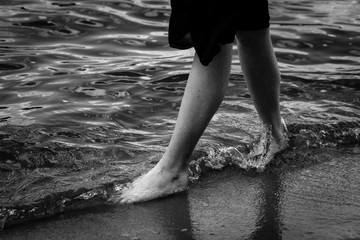 A girl is walking on the water.Black and white photo.Dress develops in the wind
