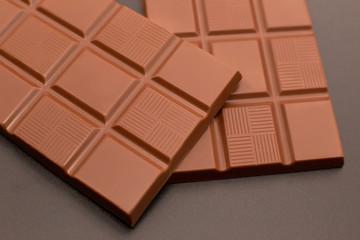 Two stylish chocolates on a dark background