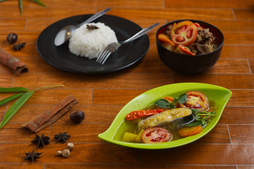 traditional indonesian catfish soup on a green plate over wooden background.