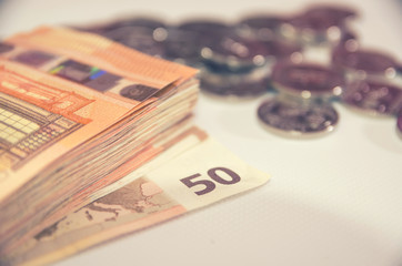 50 euro banknotes on a background of coins. Business concept. Image is tinted.