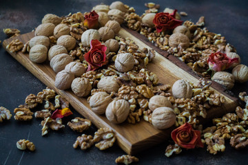 Shelled and shelled walnuts on a wooden board on the table. Healthy nutrition, vegetarianism, diet.