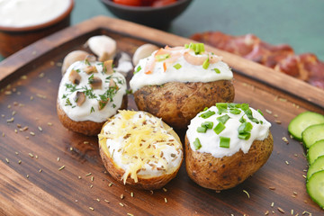 Tasty baked potato with sour cream on board